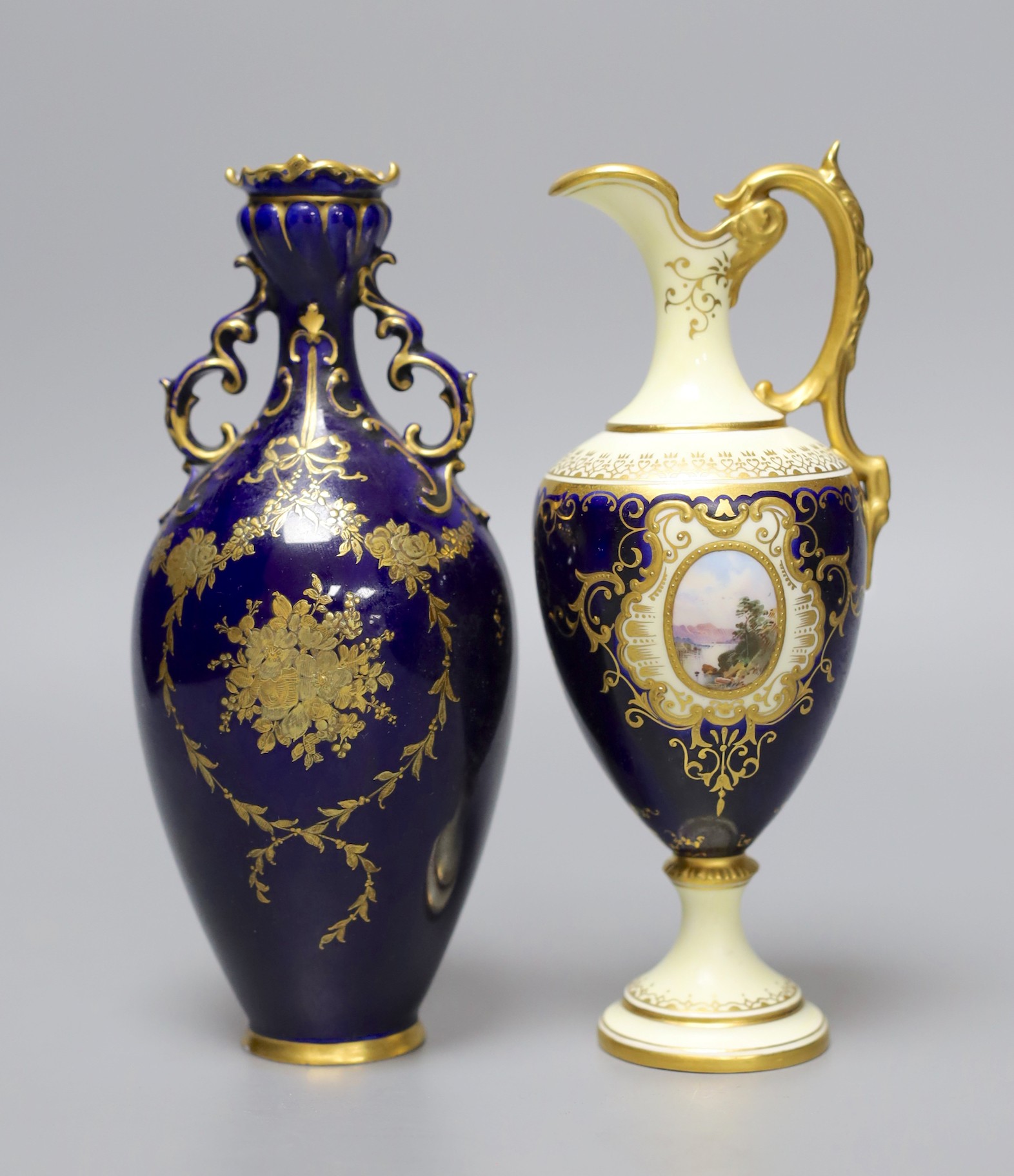 A Coalport blue ground ewer, with a gilded oval panel with a loch scene, c.1900, and a Royal Crown Derby vase with raised gilded decoration on a cobalt blue ground, date code 1898, tallest 18cm